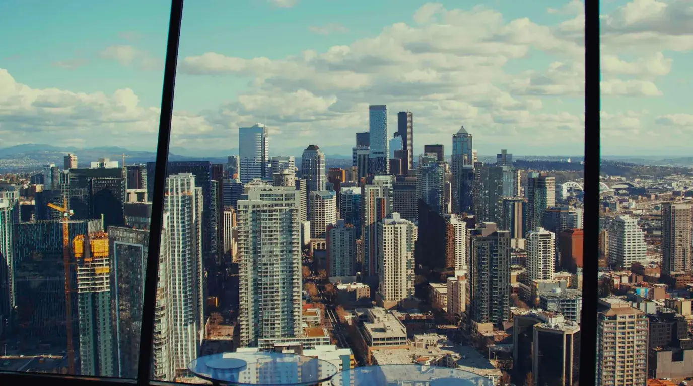 A daytime city skyline seen through an angled office window